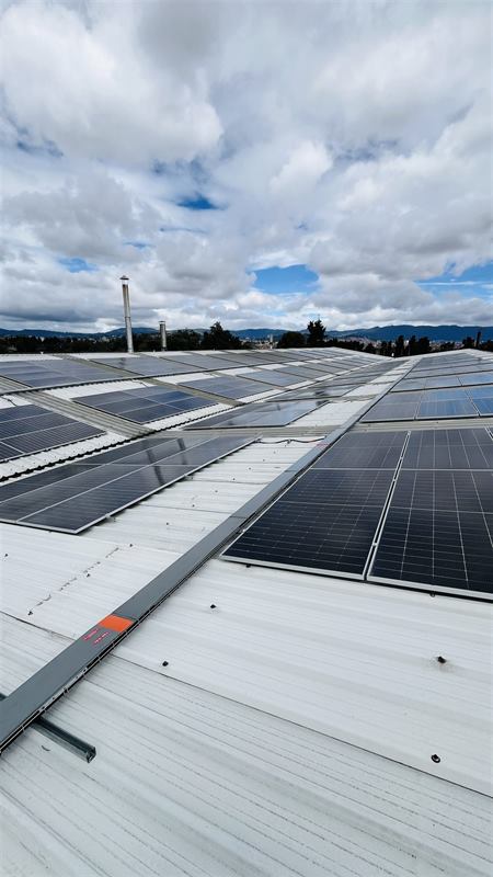 Filas de módulos solares y canaleta de cableado DC sobre cubierta metálica