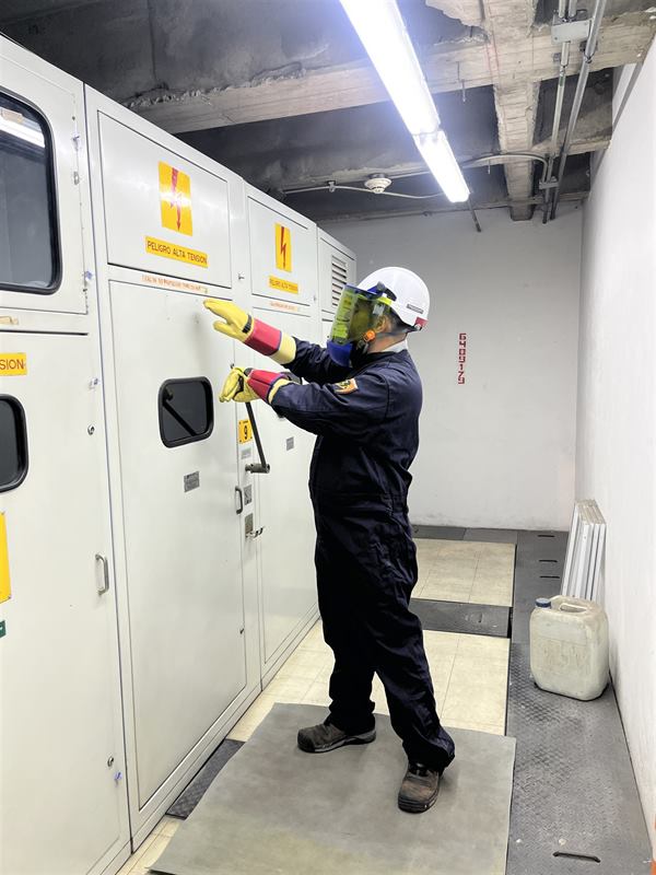 Técnico con equipo de protección maniobrando celdas de media tensión