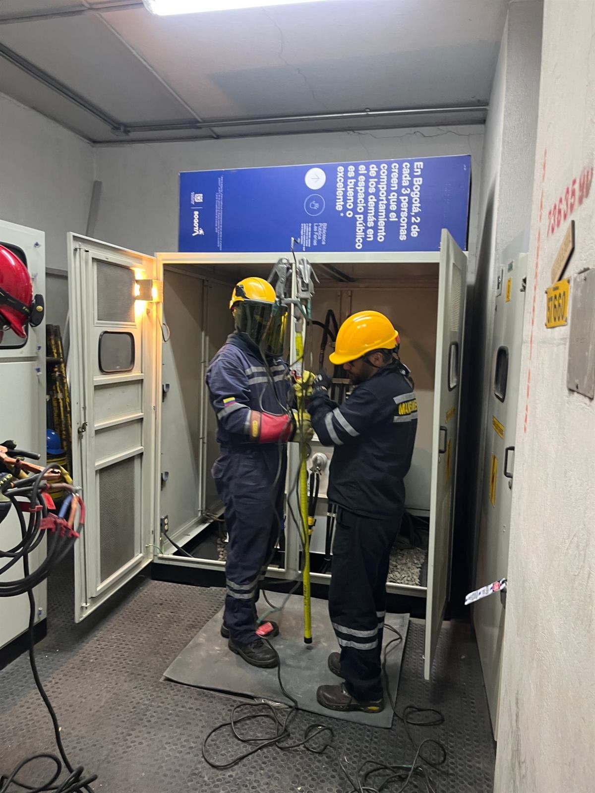 Técnicos con equipo de protección realizando mantenimiento en una subestación eléctrica
