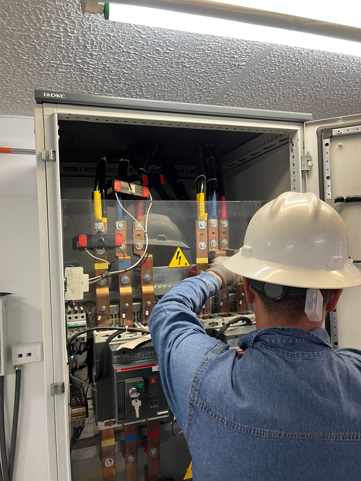 Técnico trabajando en el interior de un tablero eléctrico